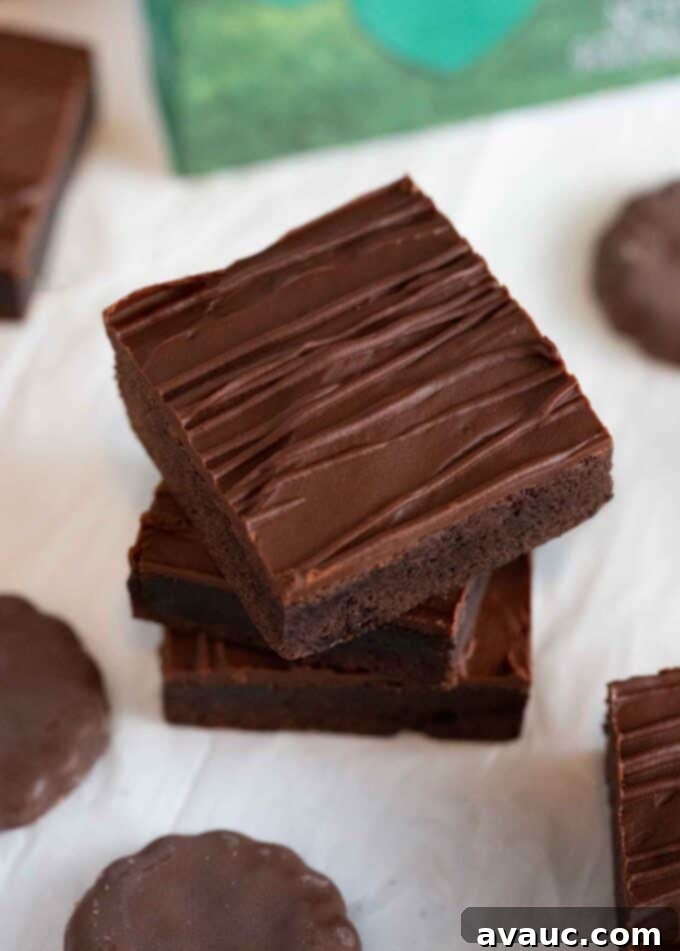 Decadent Thin Mint Cookie Bars 14 stack of chocolate thin mint square bars with chocolate drizzle