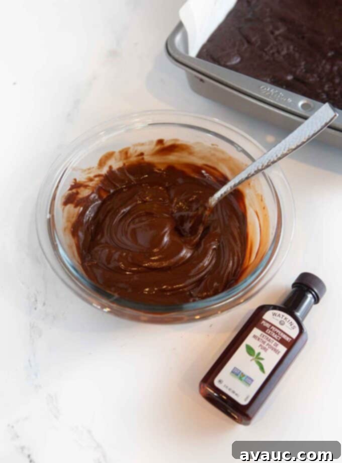 Decadent Thin Mint Cookie Bars 9 glass bowl of melted chocolate chips with peppermint extract bottle off to the side