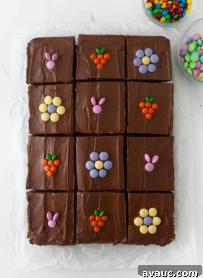 Easter brownies with M&M's on top, decorated as bunnies, carrots, and flowers, arranged on a white platter.