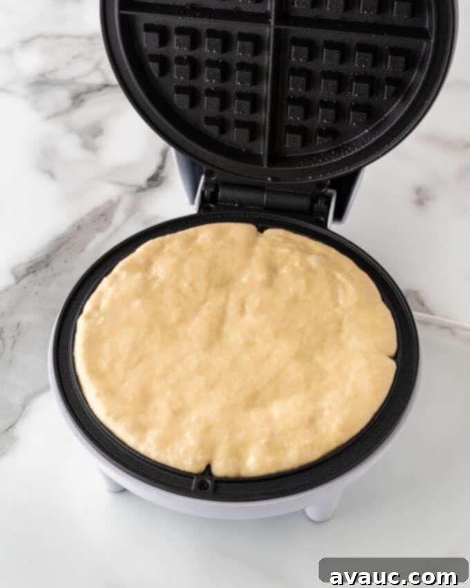 crispy waffle batter spread evenly to the edges in the waffle iron
