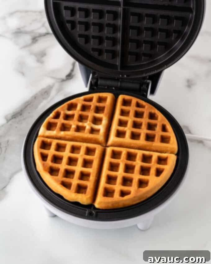 golden brown baked crispy waffle in a round waffle iron, perfectly cooked