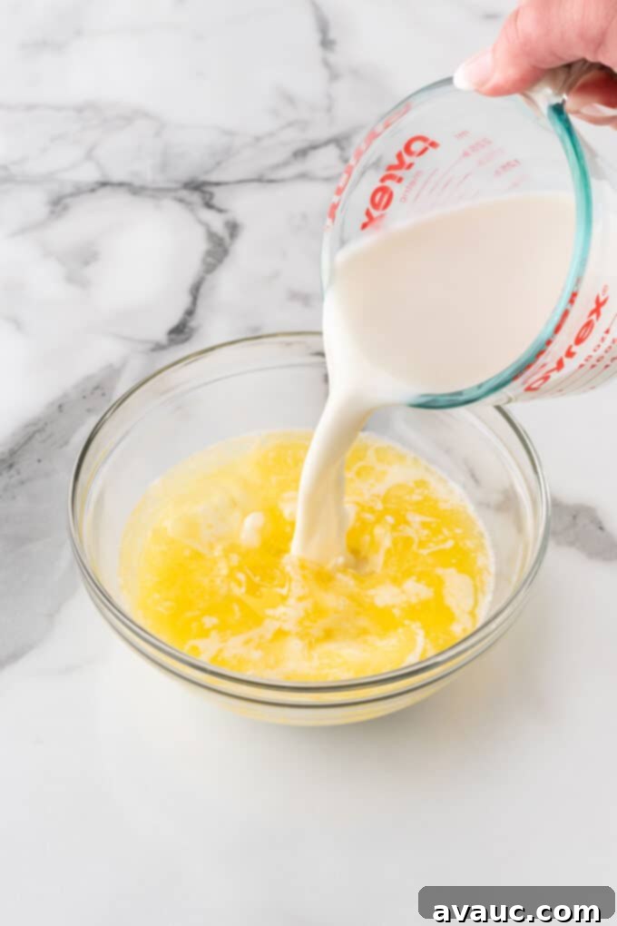 combining wet ingredients for crispy waffle batter, showing melted butter, milk, and oil