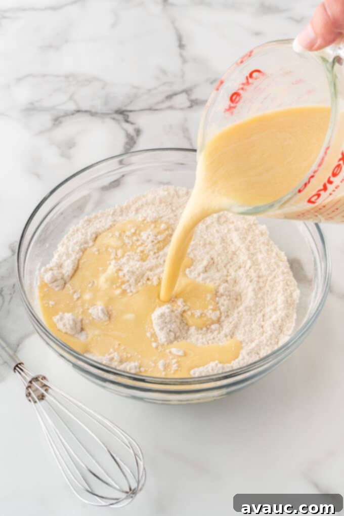 pouring wet ingredients into dry ingredients to create crispy waffle batter
