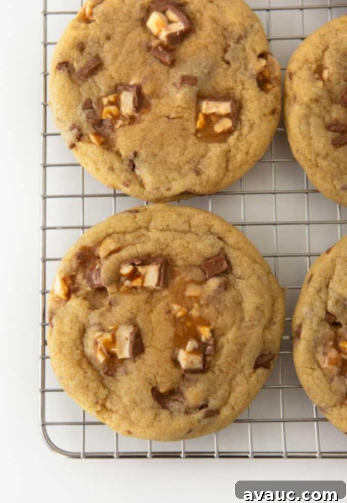 Decadent Chewy Snickers Cookies 3 Several baked Snickers cookies on a wire cooling rack