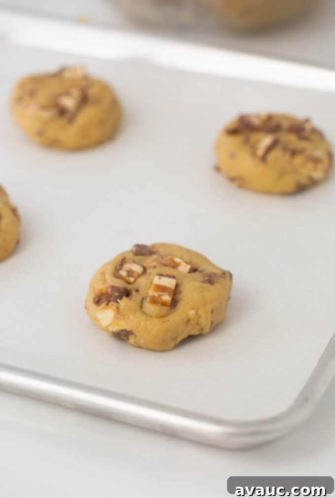 Decadent Chewy Snickers Cookies 7 Cookie sheet with Snickers cookie dough rolled into balls and slightly flattened