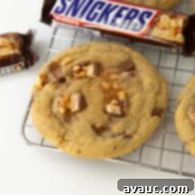 Decadent Chewy Snickers Cookies 9 snickers cookies on wire cooling rack with candy bar