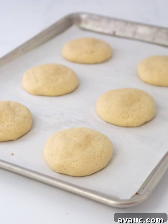 Coconut Cloud Sugar Cookies 7 Freshly baked, unfrosted coconut sugar cookies cooling on a baking tray.