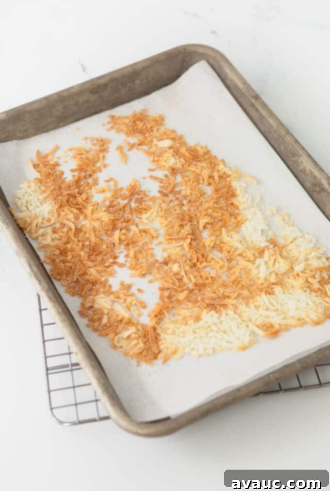 Coconut Cloud Sugar Cookies 8 Un-toasted coconut flakes spread out on a baking sheet, ready for the oven.