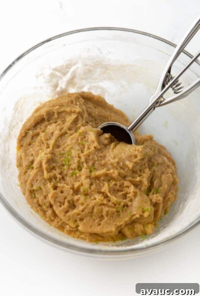 chewy key lime cookie dough in bowl with 3-tablespoon cookie scoop
