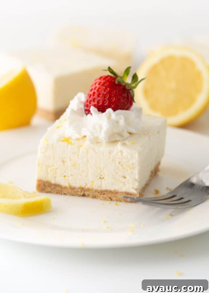 Easy No Bake Lemon Cheesecake Squares 2 square of no bake lemon cheesecake on plate with whipped cream and strawberry on top
