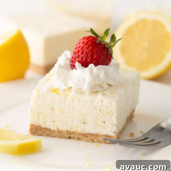 Easy No Bake Lemon Cheesecake Squares 14 square of no bake lemon cheesecake on plate with whipped cream and strawberry on top