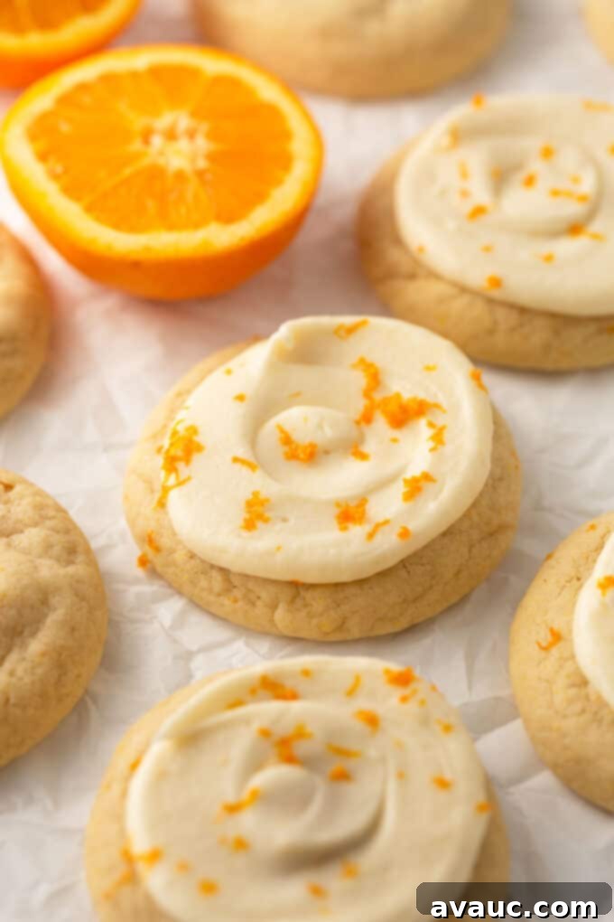 Glazed Orange Sugar Cookies 2 orange sugar cookies with orange zest on top, beautifully frosted