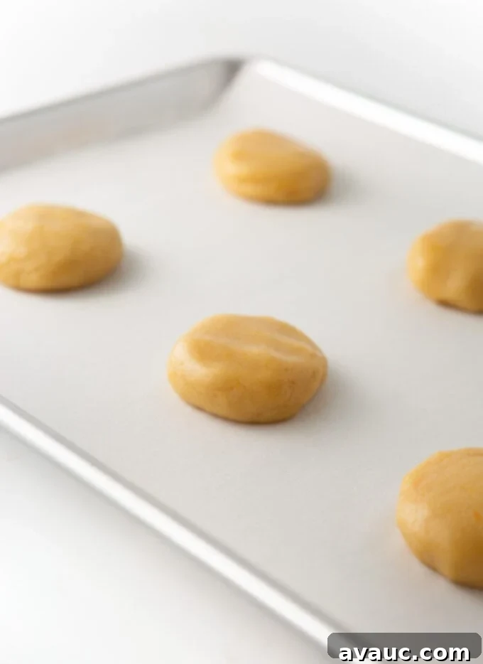 Glazed Orange Sugar Cookies 6 orange sugar cookie dough balls slightly flattened on parchment-lined cookie sheet