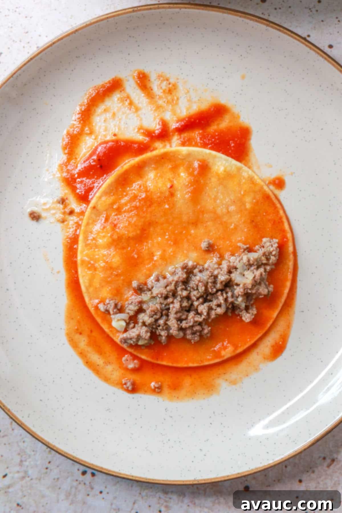 Corn tortilla with tomato sauce and ground beef filling