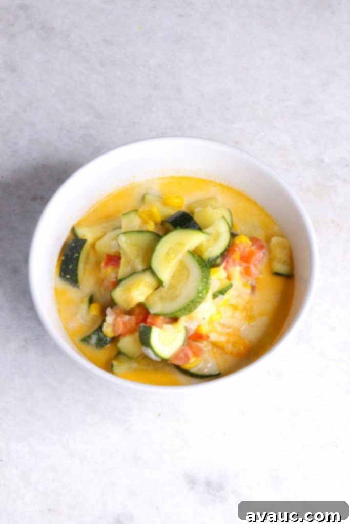 Cheesy Calabacitas 10 A single white bowl filled with creamy, cheesy Calabacitas con Queso, garnished and ready to enjoy