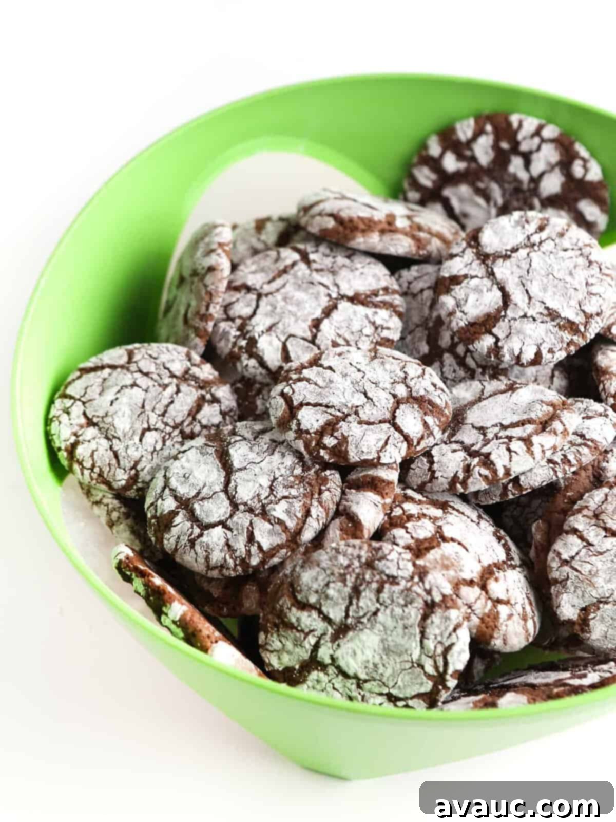Close-up of baked chocolate brownie cookies with a perfect crackle top, arranged on a blue plate, ready to be enjoyed or stored.