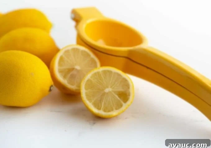 Easy Strawberry Lemonade 3 Hand juicing a fresh lemon with a manual citrus juicer, highlighting the use of fresh ingredients.
