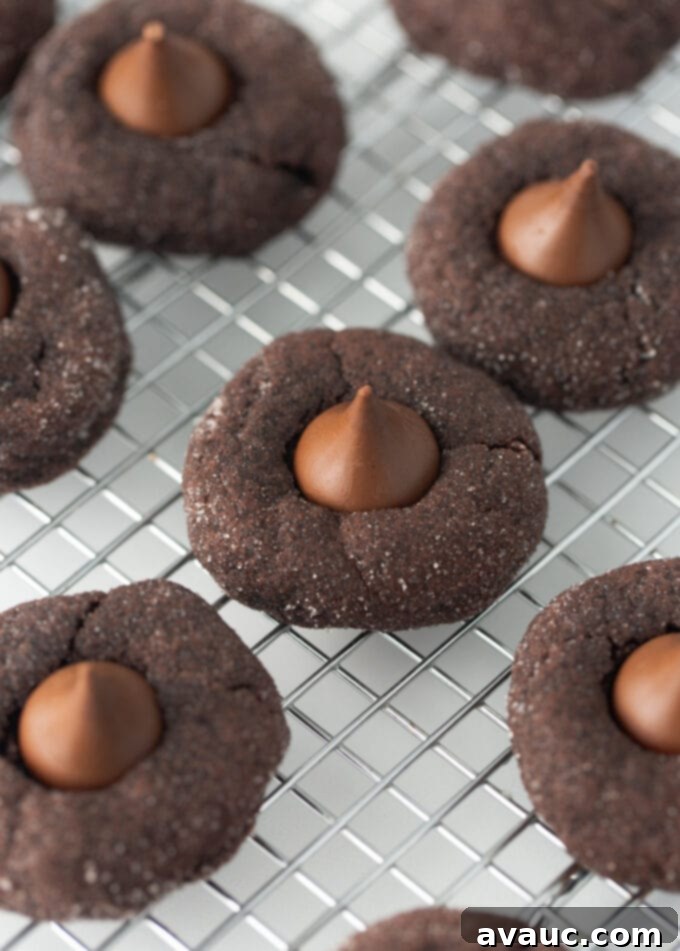 Decadent Fudgy Chocolate Blossoms 2 Fudgy chocolate blossom cookie on a wire cooling rack, showcasing its chewy texture and melted Hershey Kiss.