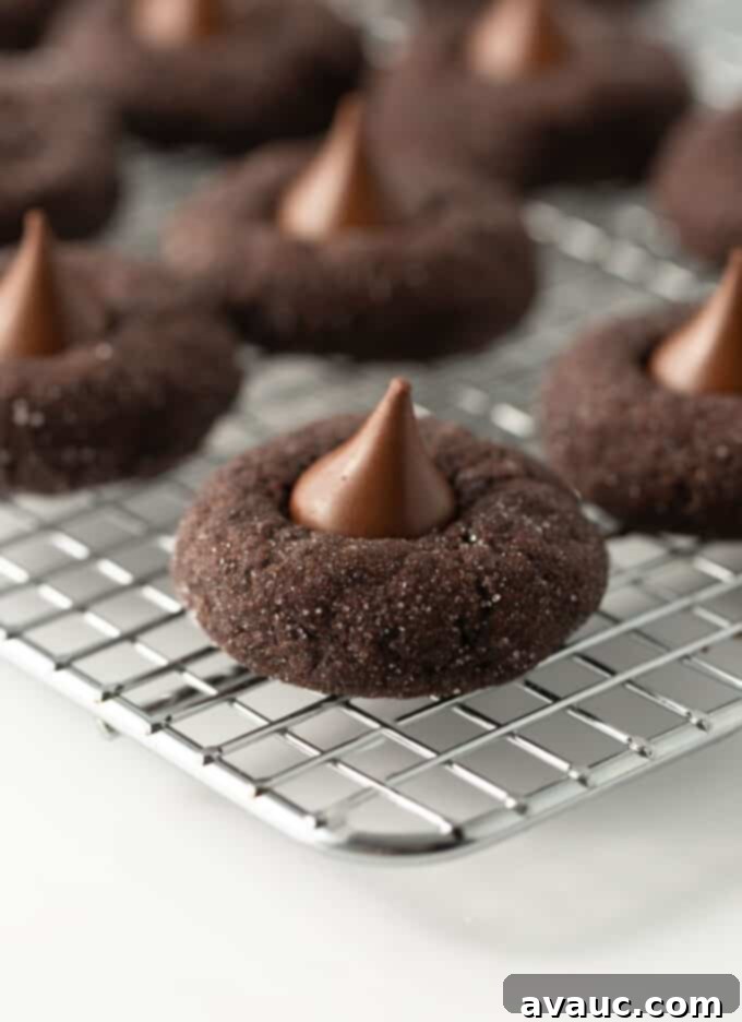 Decadent Fudgy Chocolate Blossoms 8 Finished double chocolate blossom cookies with Hershey Kisses on a wire rack, cooling.
