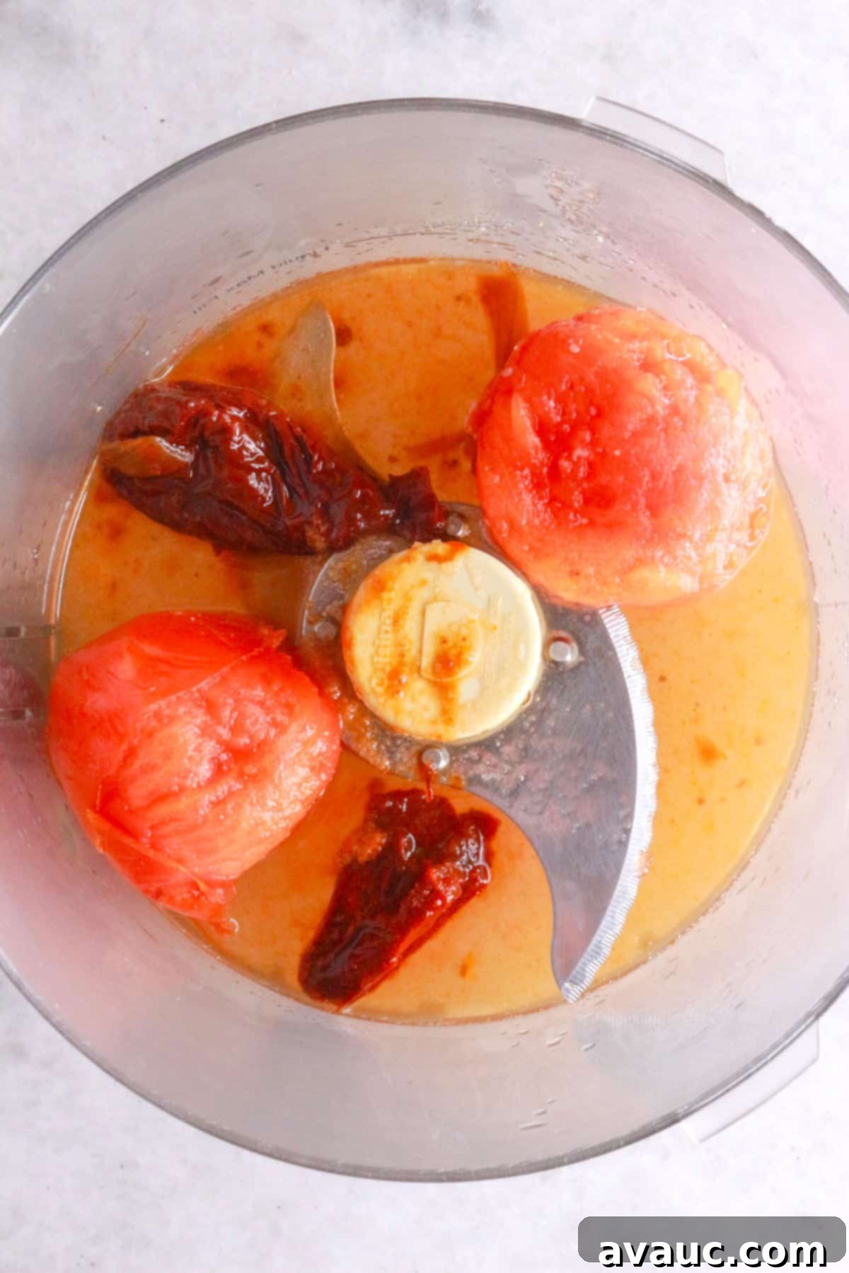 Chipotle peppers and boiled tomatoes in a food processor