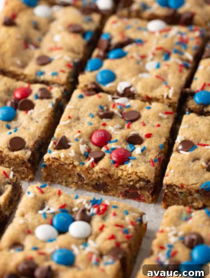 squares of 4th of july monster cookie bars, showcasing red, white, and blue candies and a rich, chewy texture