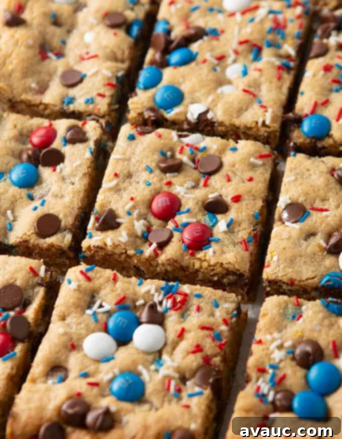 close up of cut squares of 4th of july monster cookie bars, stacked and ready for storage in an airtight container