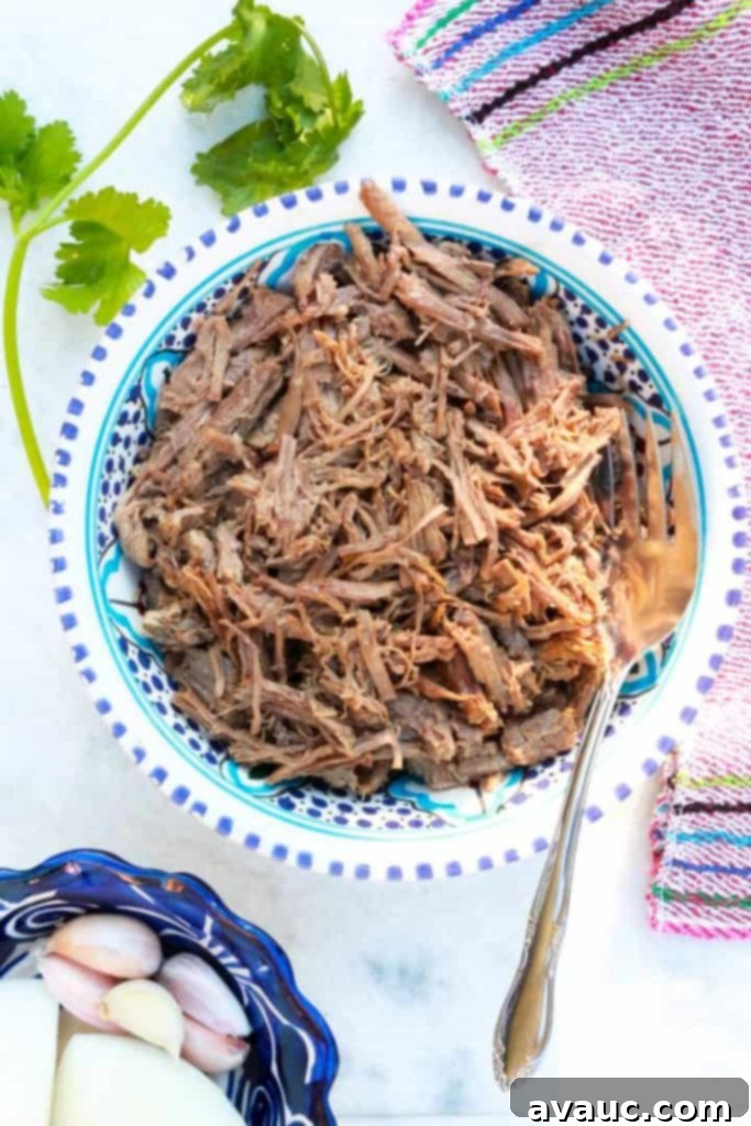 A bowl filled with rich, savory shredded beef, cooked to perfection in an Instant Pot, ready to be served for a delicious meal.