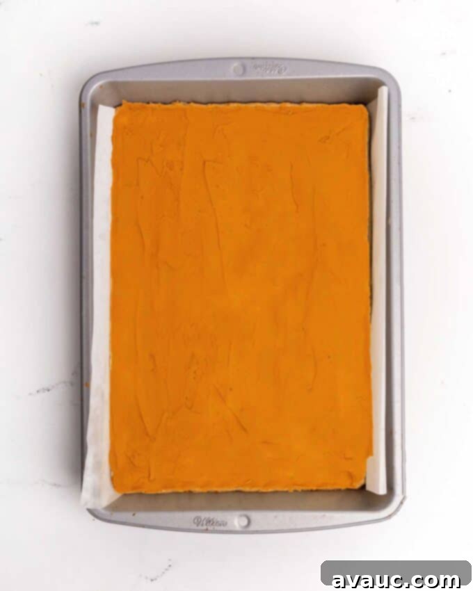 9x13 pan of sugar cookie bars with orange frosting