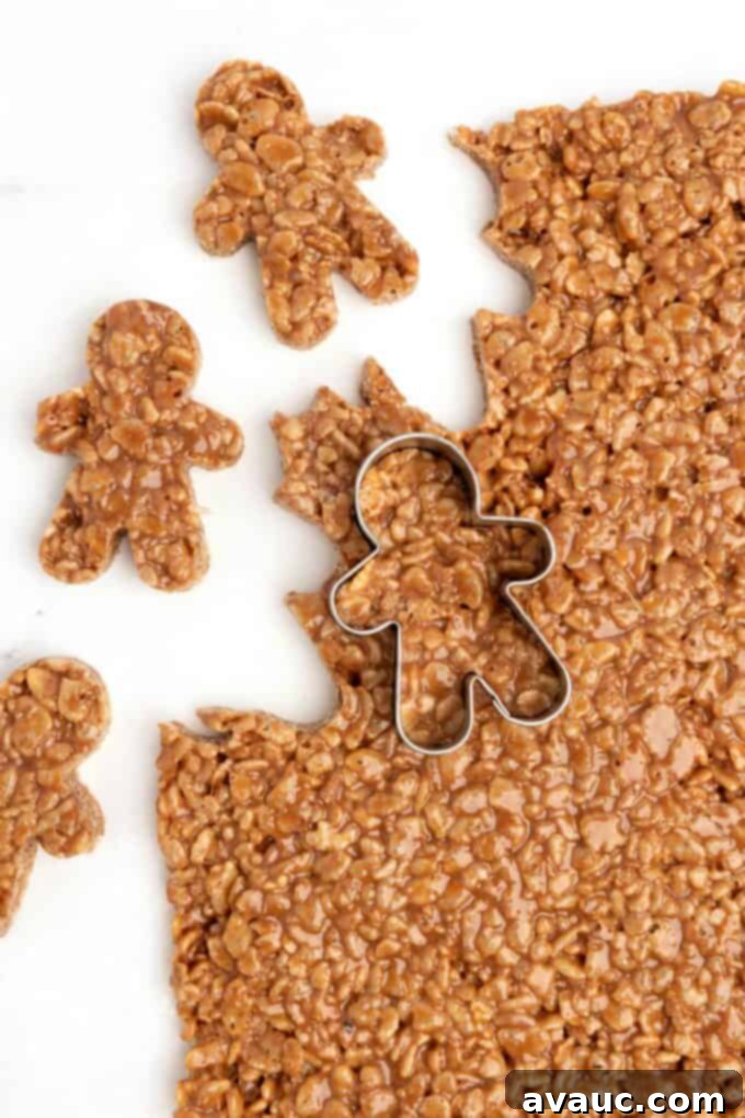 Spiced Gingerbread Krispie Treats 15 A mini gingerbread cookie cutter actively cutting out star crunch rice krispy bars from the pan