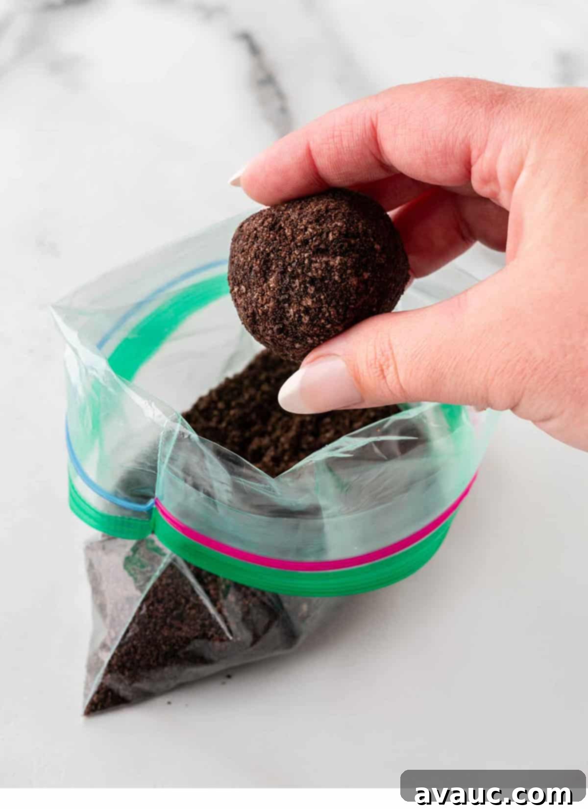No-Dip Oreo Truffles 12 Hand rolling an Oreo truffle ball in a bag of Oreo crumbs for an even coating.