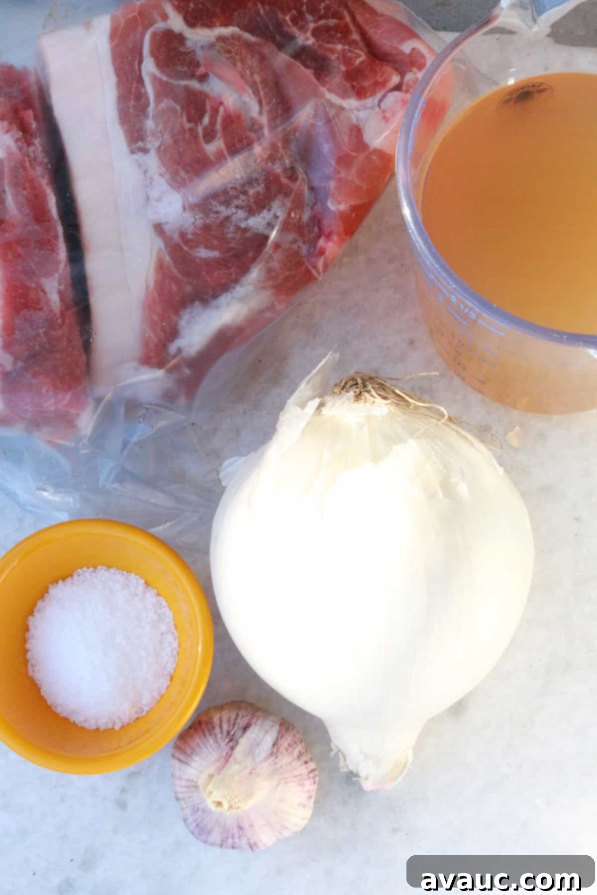 Crispy Golden Carnitas 3 A selection of ingredients for Mexican shredded pork: pork shoulder, chicken broth, garlic, onion, and salt.