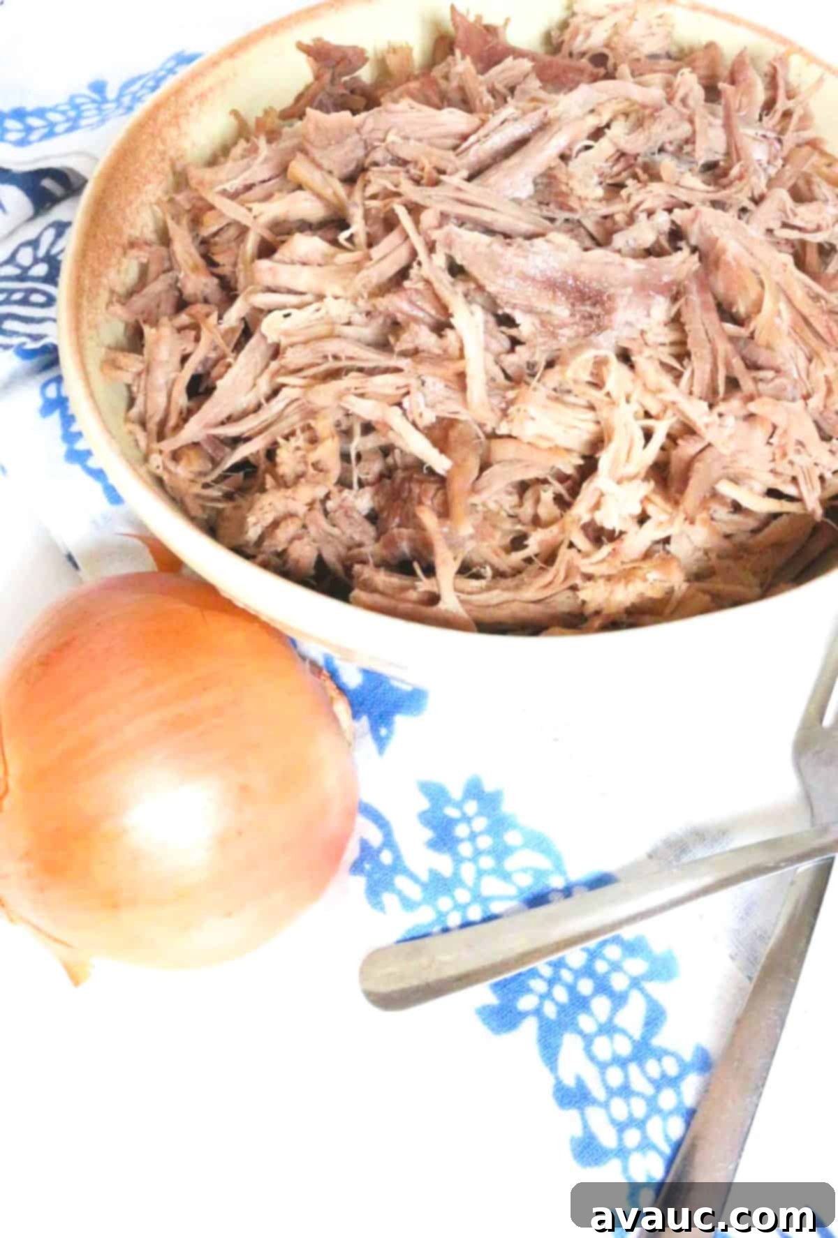 Crispy Golden Carnitas 6 A large platter of shredded Mexican pork, garnished with fresh cilantro, showcasing its tender texture.