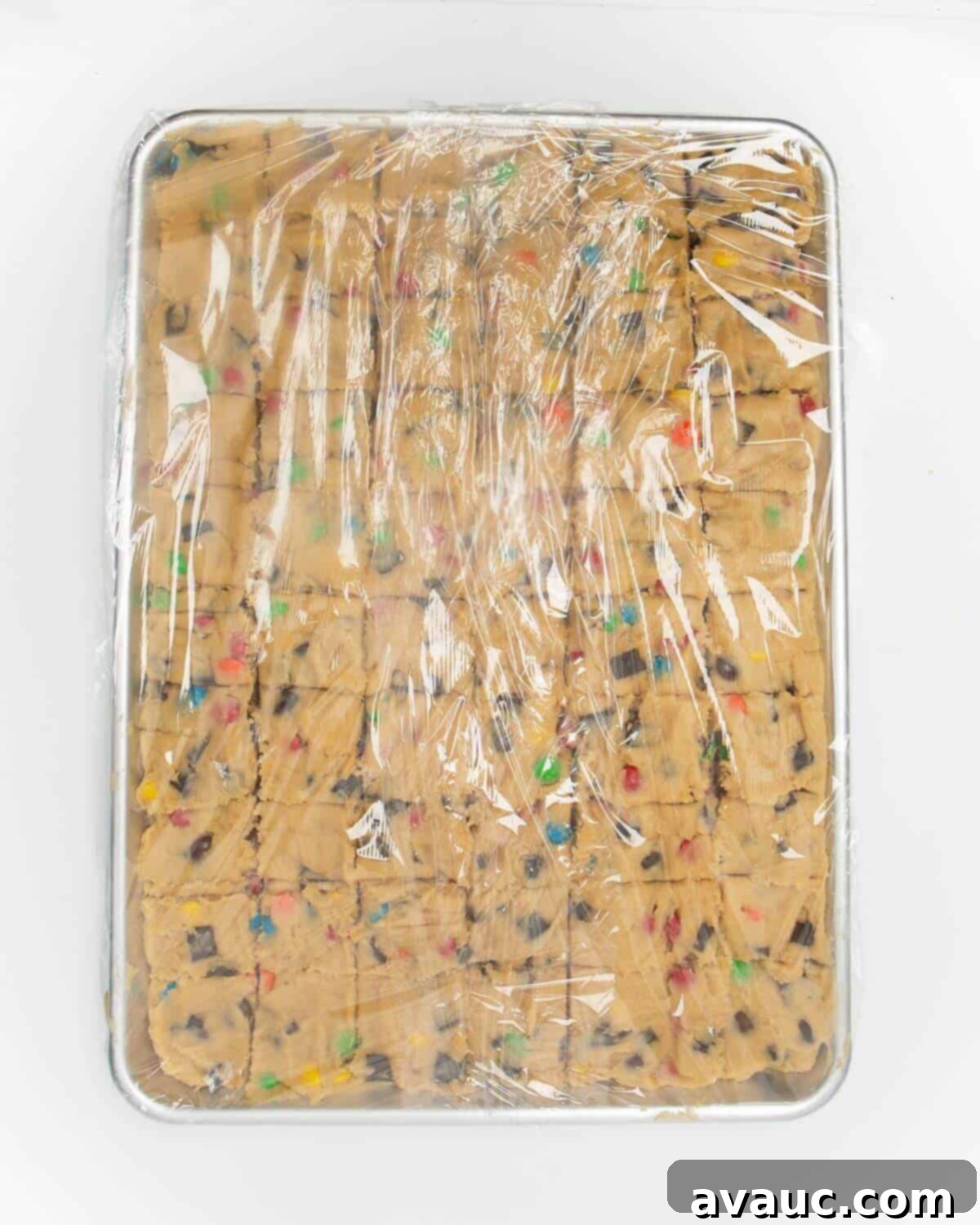The cut cookie dough, still in the metal pan, tightly wrapped in plastic wrap for freezing.