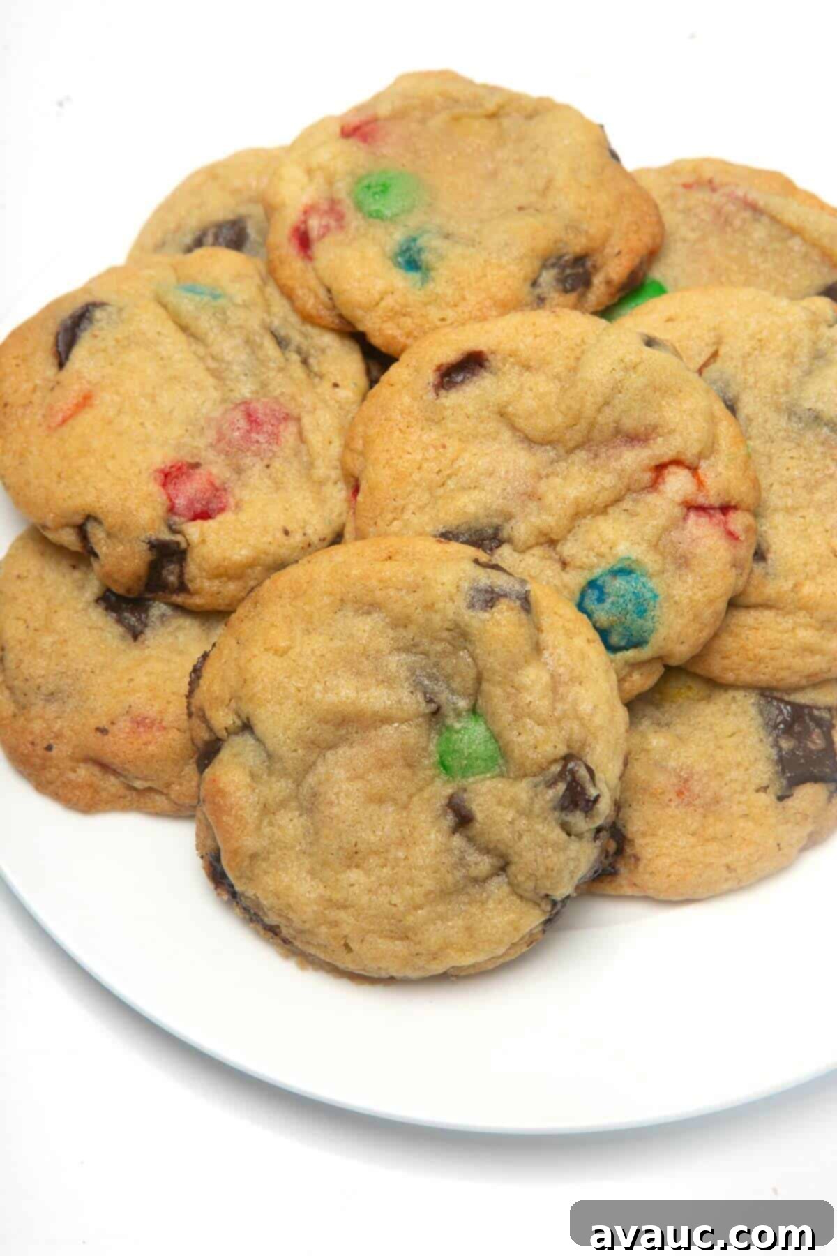 A plate of golden-brown, freshly baked chocolate chip cookies, slightly crisp at the edges and chewy in the center.