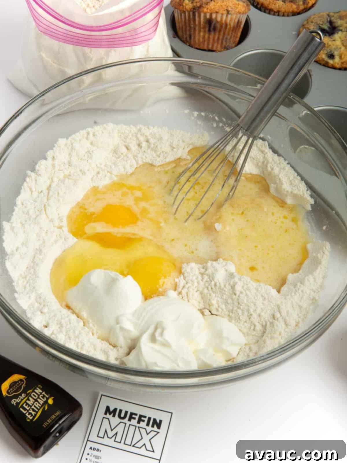 Whip Up Your Own Muffin Mix 7 Muffin mix being combined with wet ingredients in a bowl to form batter.
