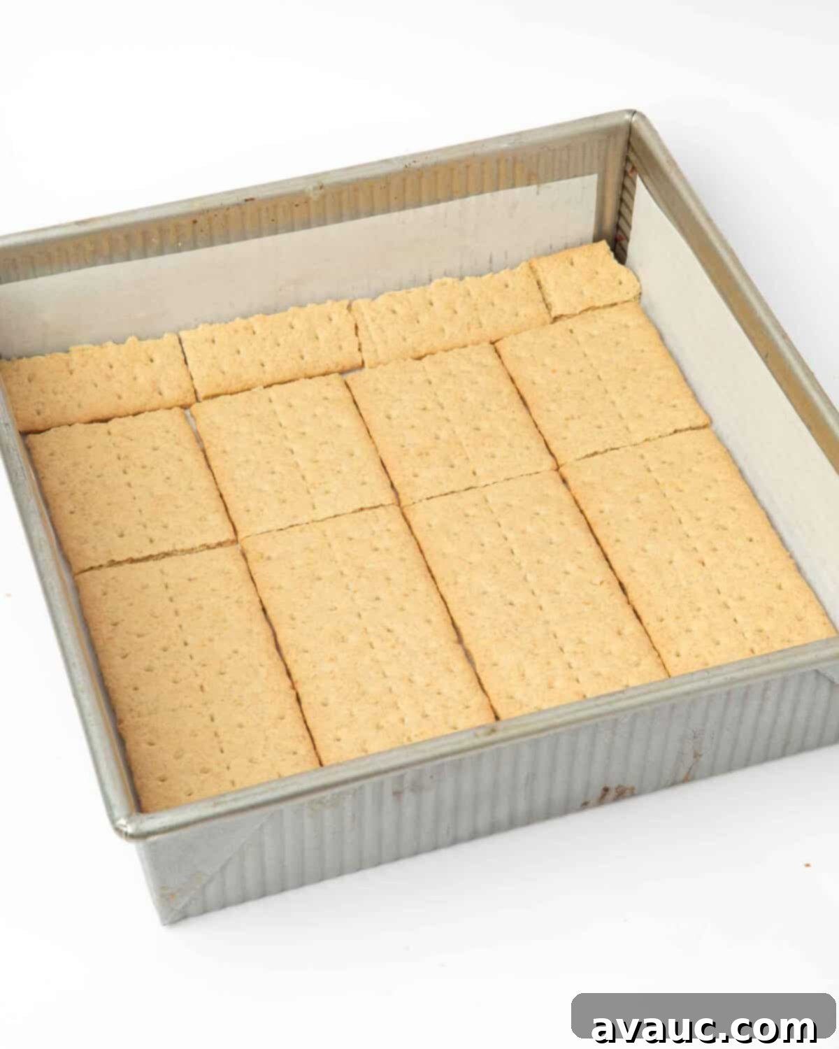 S'mores Brownies 7 9x9" light-colored aluminum metal pan lined with parchment paper and graham crackers.