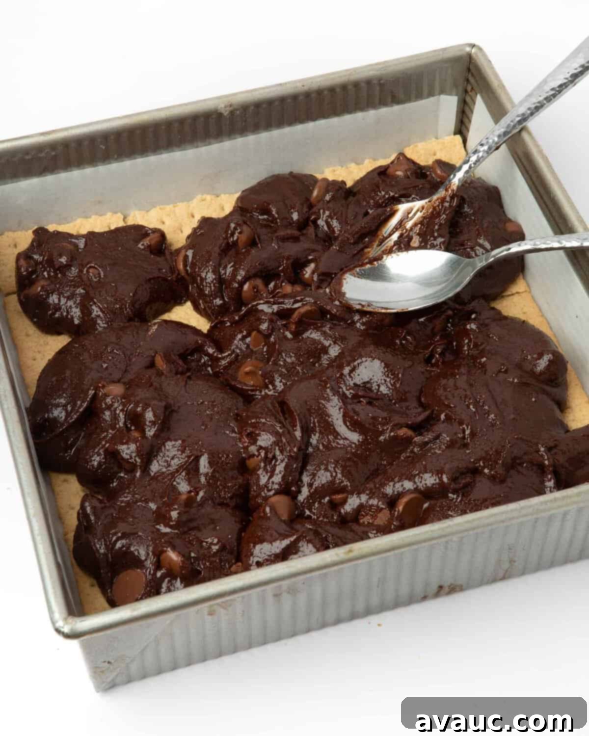 S'mores Brownies 8 Spreading thick brownie batter evenly over the graham cracker layer in a baking pan.