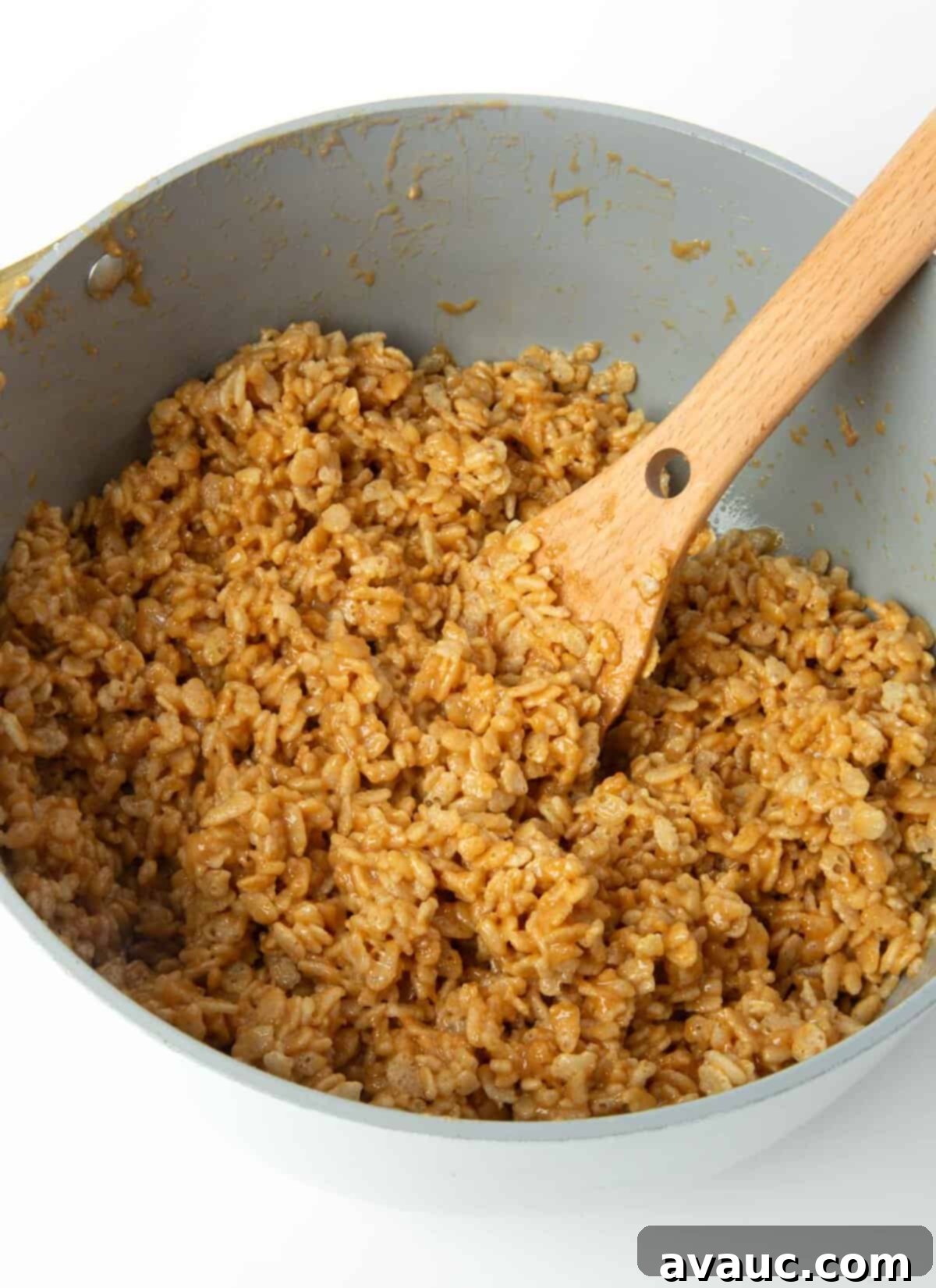 scotcheroo mixture being stirred in a large pot with crispy rice cereal