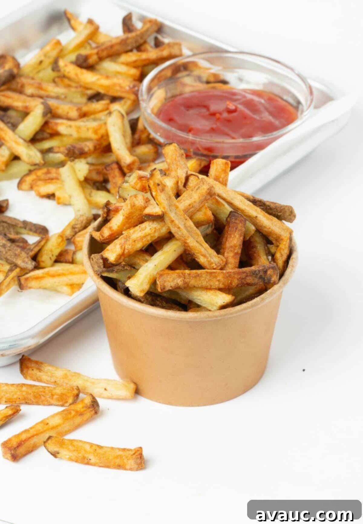 Freshly made air fryer french fries in a small paper bowl, ready for serving