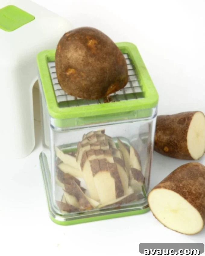 A potato being expertly cut into uniform fries using a specialized french fry cutter