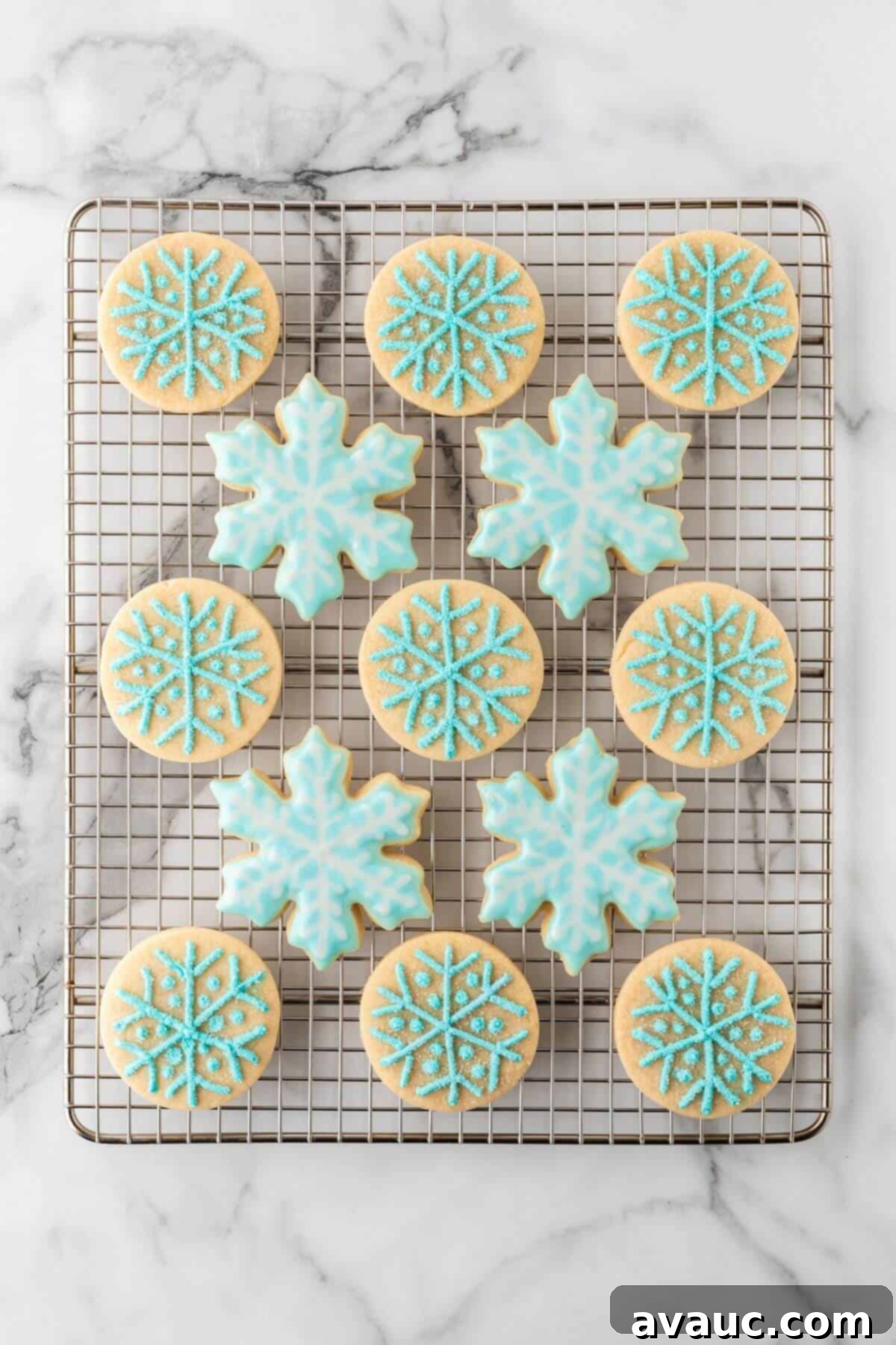 Frosted snowflake sugar cookies cooling on a wire rack