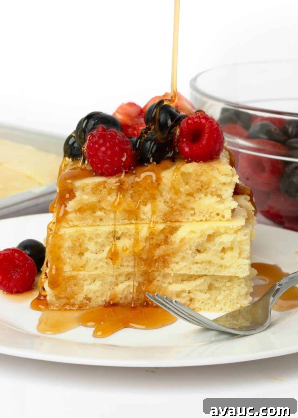 Sheet Pan Pancake Perfection 2 Stack of fluffy sheet pan pancakes with fresh fruit and maple syrup drizzled on top, ready for breakfast.
