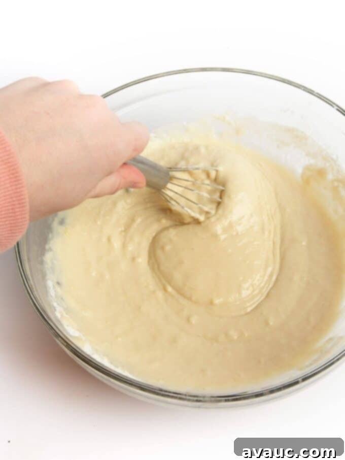Sheet Pan Pancake Perfection 6 Perfectly mixed pancake batter in a glass mixing bowl, showing a few small lumps, ready for baking.