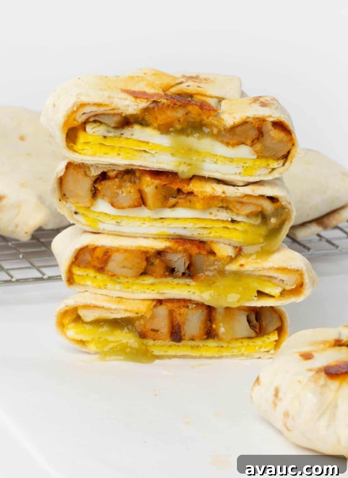 Crispy Breakfast Wraps 2 two breakfast crunchwraps cut in half stacked on top of each other, revealing layers of egg, potato, and cheese