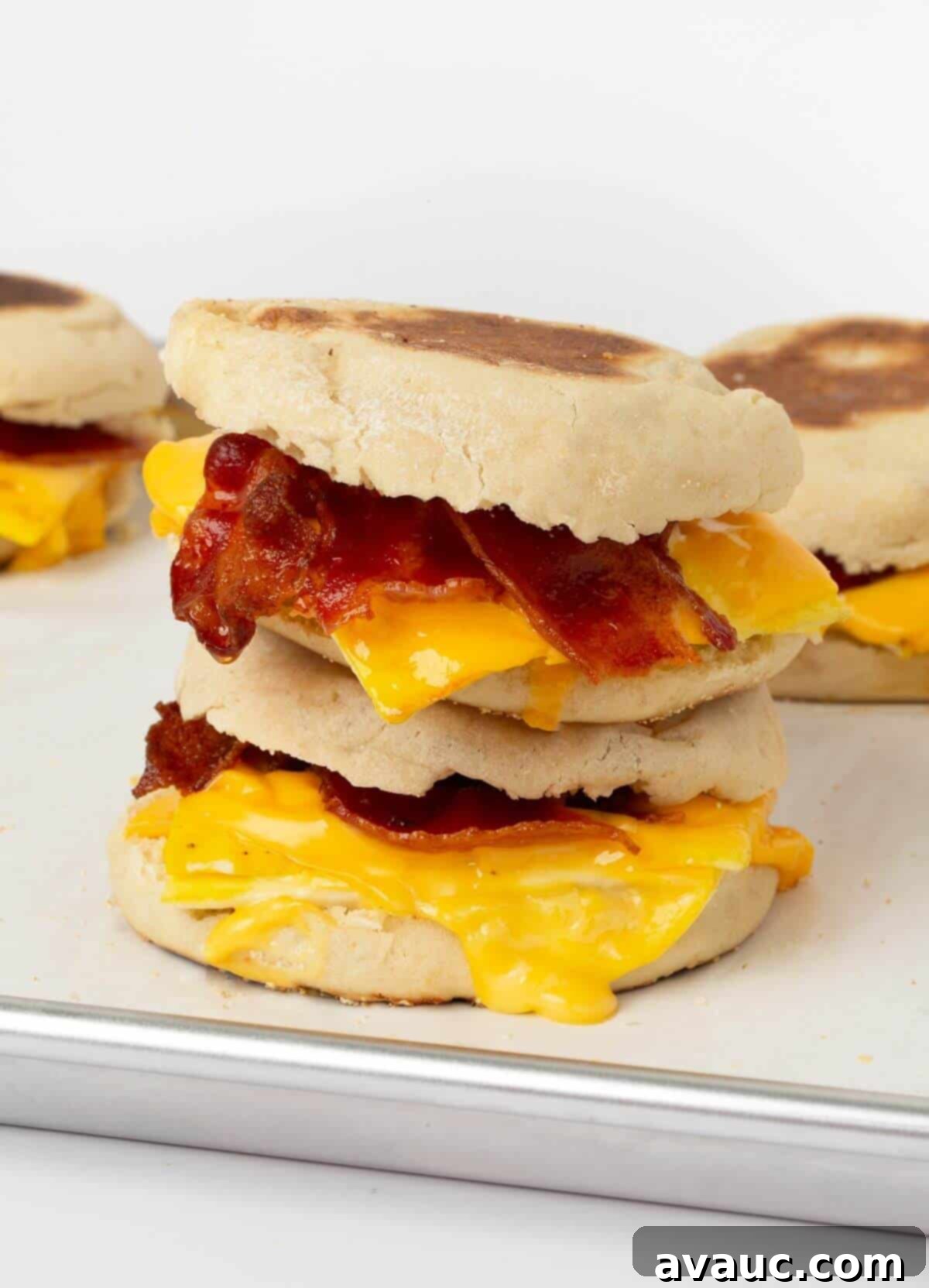 On-the-Go Breakfast Sandwiches 2 Two homemade freezer breakfast sandwiches stacked on a baking tray, ready for a quick breakfast