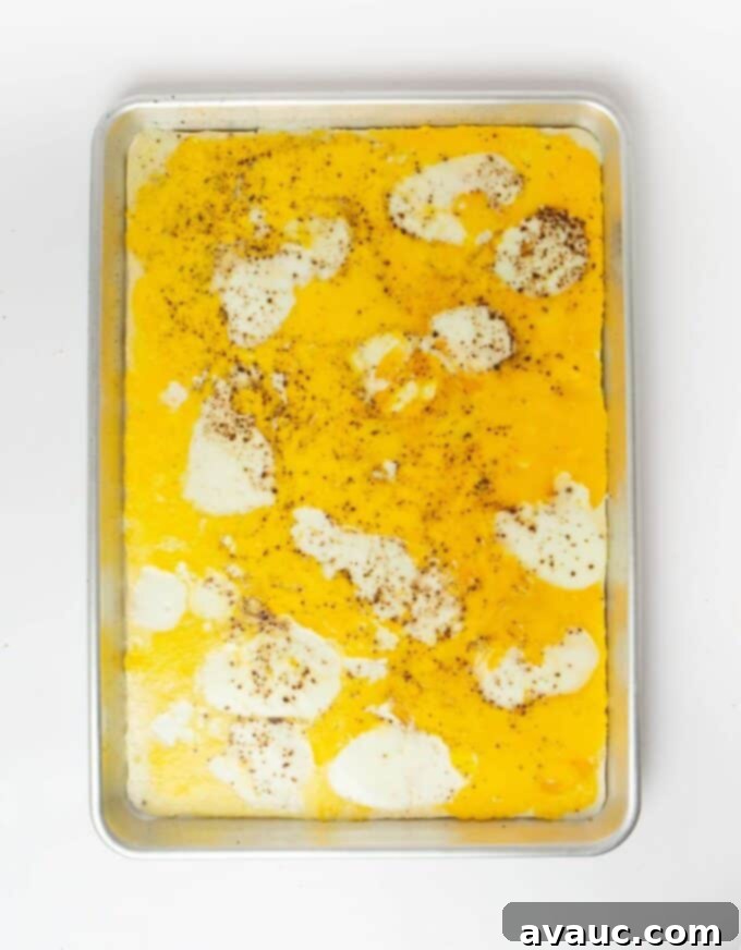 sheet pan eggs on baking sheet seasoned with salt and pepper