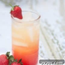 Sunrise Berry Citrus Sparkler 8 Orange Berry Sunrise Spritzer served in a glass with fresh strawberries.