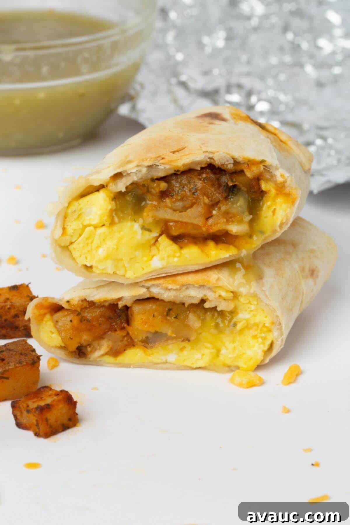 breakfast burrito cut in half, revealing crispy potatoes, fluffy eggs, and melted cheese