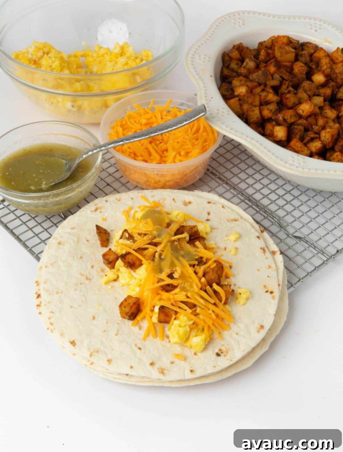 flour tortilla with a neat stack of egg, cheese, potatoes, and salsa in the middle