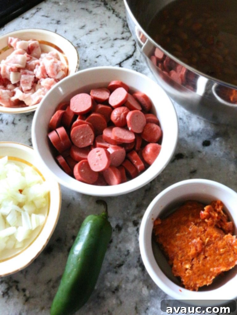 A vibrant display of fresh ingredients laid out for making Frijoles Charros, including pinto beans, diced bacon, chorizo, onions, jalapeños, and cilantro. #frijolescharros #mexicanbeans #charrobeansingredients #freshingredients